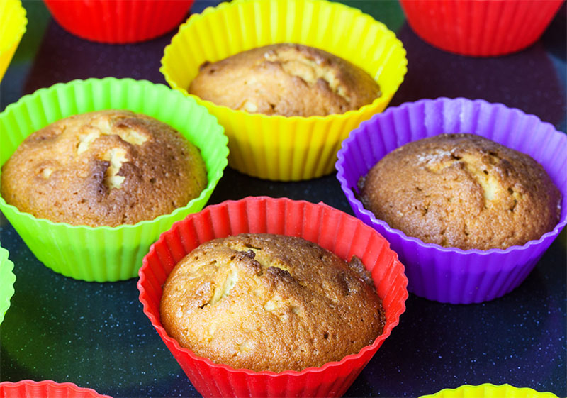 Baked cupcakes in different coloured silicone moulds in an air fryer